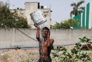 A boy bathes outside his residence on a hot summer day in New Delhi
