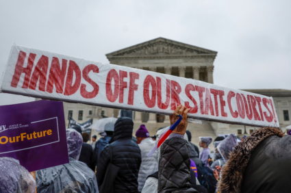 Demonstrators gather outside of the United States Supreme Court as the justices hear oral arguments in Moore v. Harper in ...
