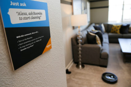 FILE PHOTO: Prompts on how to use Amazon's Alexa personal assistant are seen as a wifi-equipped Roomba begins cleaning a r...