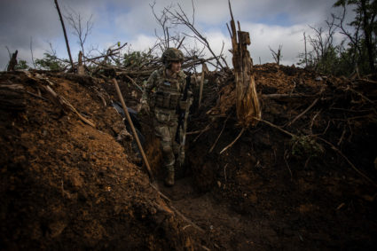 Ukrainian serviceman walks in a trench at a position near the frontline town of Bakhmut