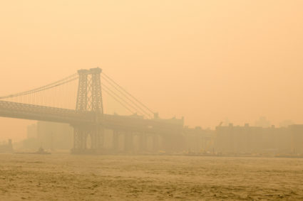 The Williamsburg Bridge is wrapped in haze and smoke caused by wildfires in Canada, in Brooklyn, New York