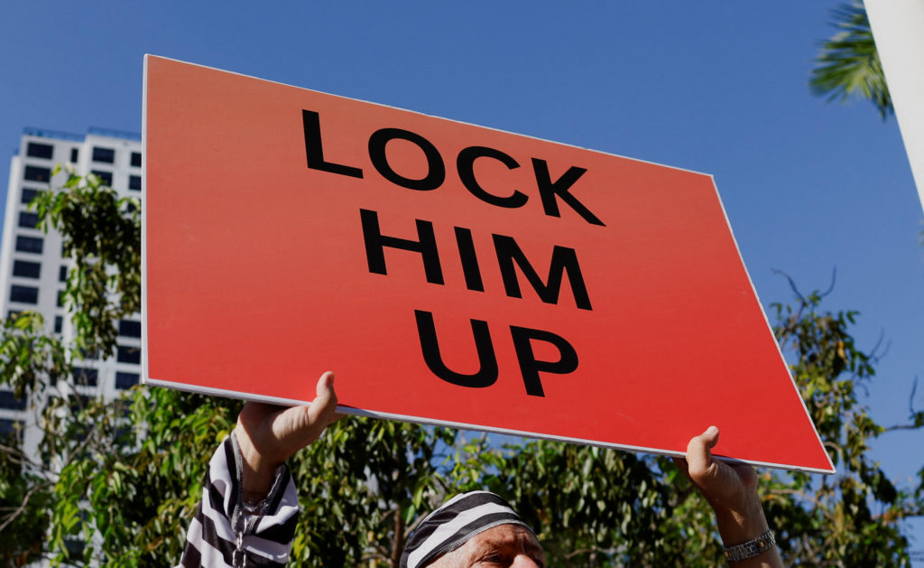 Dominic Santana holds up a sign outside The Wilkie D. Ferguson Jr. United States Courthouse, in Miami