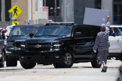 A man gestures as the motorcade of former U.S. President Donald Trump arrives at the Wilkie D. Ferguson Jr. United States Courthouse, to appear at his arraignment on classified document charges, in Miami, Florida, U.S., June 13, 2023. Photo by Brendan Mcdermid/REUTERS