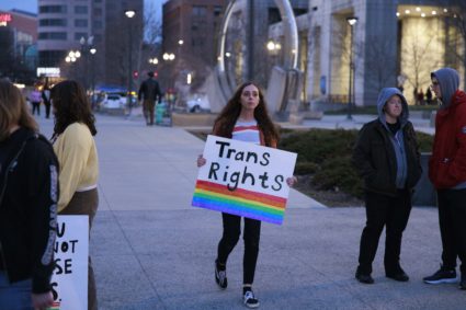 A protester holding a placard reading, Trans Rights,
