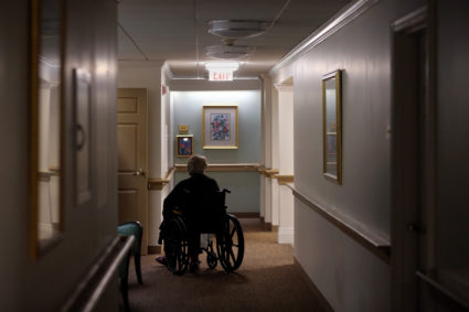 Man in a wheelchair in the hallway of a nursing homes