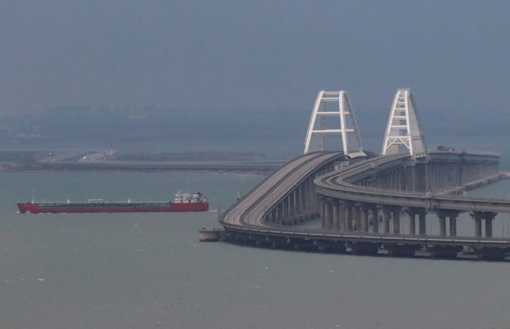 A cargo ship sails next to the Kerch bridge, after an explosion destroyed part of it, in the Kerch Strait, Crimea
