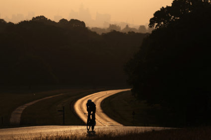 Cyclist trains early morning as hot weather continues, in London