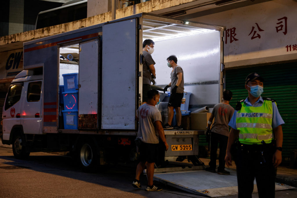 Movers collect boxes of evidence after the arrest of four men on suspicion of conspiracy to collude with foreign forces and acts with seditious intent, two days after the police issued arrest warrants and bounties against eight overseas activists for national security, in Hong Kong, China July 5, 2023. Photo by Tyrone Siu/REUTERS