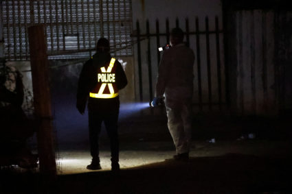 A police officer and a member of the forensic team inspect the scene of a suspected gas leak thought to be linked to illegal mining, in the Angelo shack settlement, near Boksburg, east of Johannesburg, South Africa July 6, 2023. Photo by Siphiwe Sibeko/REUTERS