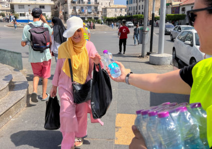 A volunteer distributes water in Algiers