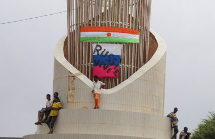 People stand next to Russian and Niger flags while hundreds of supporters of the coup gather in front of the National Assembly in the capital Niamey, Niger July 27, 2023. Photo by Balima Boureima/REUTERS