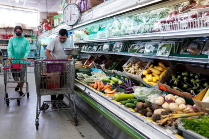 A man arranges produce at Best World Supermarket in the Mount Pleasant neighborhood of Washington, D.C., U.S., August 19, 2022. Photo by Sarah Silbiger/REUTERS