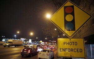 Cars approach an intersection where a red light camera is placed in Chicago