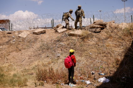 Migrants stand near the Rio Bravo river after crossing the border, to request asylum in the United States, as seen from Ci...