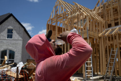 Builder takes water break during hot weather in Manvel, Texas