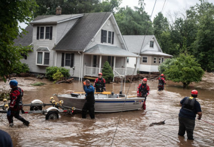 Emergency personnel maneuvre a boat which was used to rescue residents in Stony Point