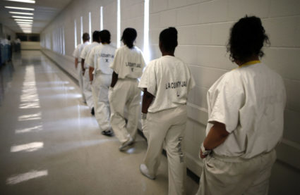 Women walk along a corridor at the Los Angeles County women's jail in Lynwood