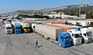 FILE PHOTO: Trucks carrying aid from the UN World Food Programme (WFP) are parked at Bab al-Hawa crossing