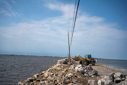 Rocks are added to an eroding Island Road, which is the only way onto Isle de Jean Charles, Louisiana, U.S., April 8, 2021. The Biloxi-Chitimacha-Choctaw tribe has lived on Isle de Jean Charles for nearly 200 years and they are now in the process of resettlement, which will be the nation's first federally-funded HUD climate resilience grant to relocate a Louisiana community affected by climate change. Picture taken April 8, 2021. Photo by Kathleen Flynn/REUTERS