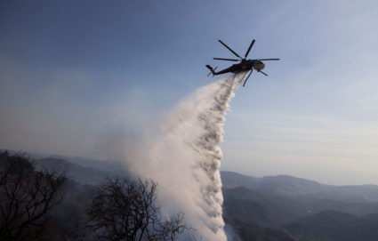 A firefighting helicopter makes a water drop on flames from the Alisal fire in Aguajito Canyon near Santa Barbara, California, U.S., hoto by October 14, 2021. Aude Guerrucci/REUTERS