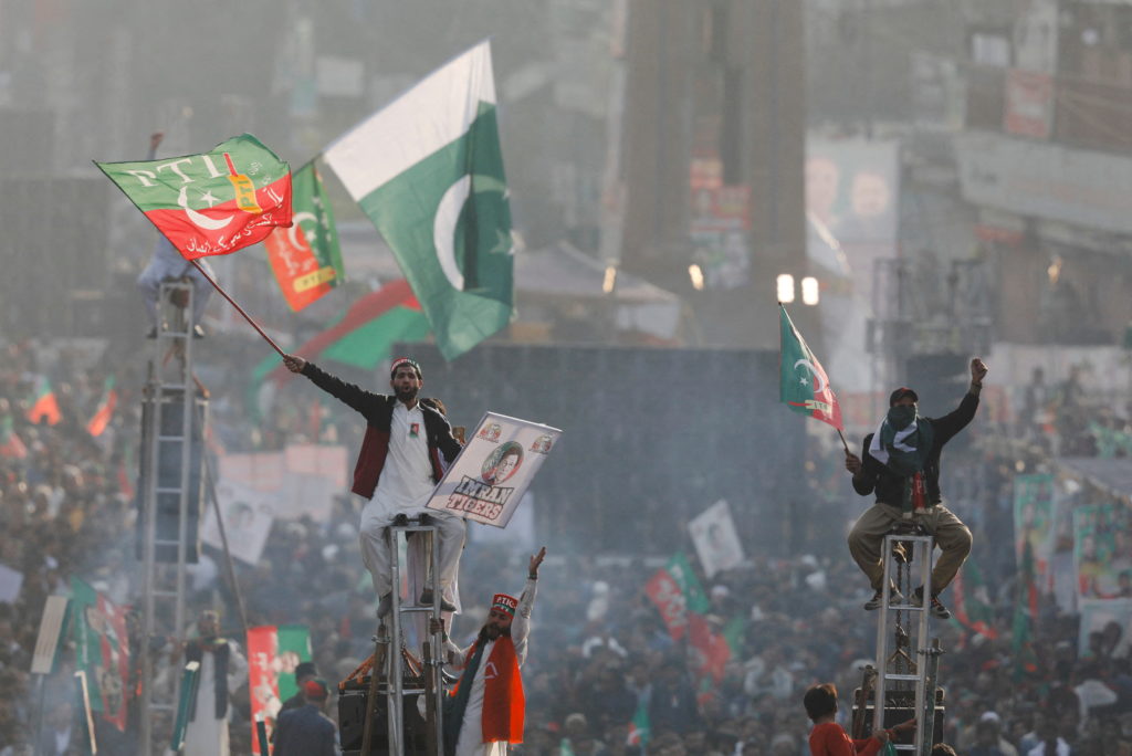 Supporters of the Pakistan's former Prime Minister Imran Khan sit on scaffoldings to see their leader in his first public ...