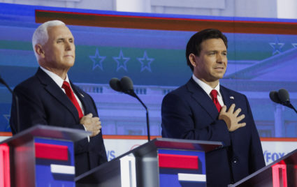 Former U.S. Vice President Mike Pence and Florida Governor Ron DeSantis stand behind their podiums for the U.S. Pledge of Allegiance at the first Republican candidates' debate of the 2024 U.S. presidential campaign in Milwaukee, Wisconsin, U.S. August 23, 2023. Photo by Jonathan Ernst/REUTERS