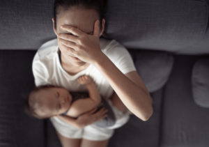Tired mother holding head