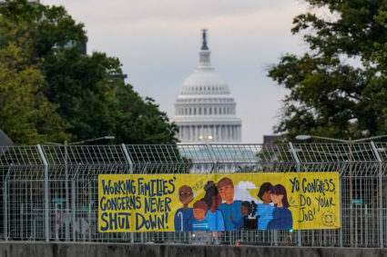 A view of a working families poster as the U.S. Capitol is seen in the background, as the deadline to avert a partial gove...