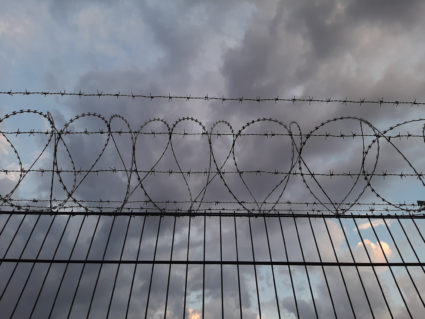 Low angle view of barbed wire against sky