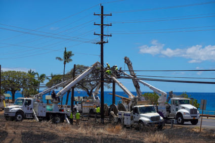 FILE PHOTO: Workers repair utility lines in the fire ravaged town of Lahaina