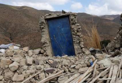A blue door is seen surrounded by rubble in the devastated village of Adouz