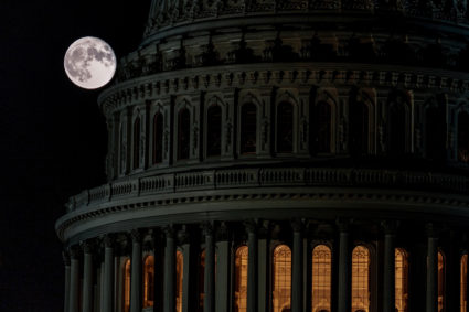 The super moon known as the Blue Moon rises behind the United States Capitol in Washington