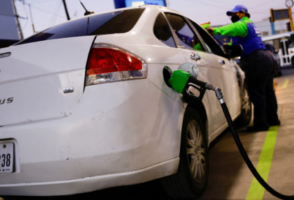 FILE PHOTO: A worker fills a car belonging to a Texas resident, with gasoline at a gas station following increased fuel pr...