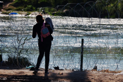 A migrant waits for others after crossing the Rio Grande and getting over the razor wire in Eagle Pass, Texas, U.S., September 29, 2023. Photo by Brian Snyder/REUTERS