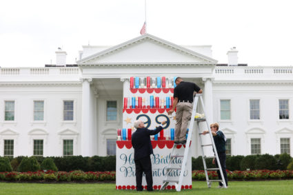 A White House electrician arranges candles on a wooden birthday cake ahead of former U.S. President Jimmy Carter's birthday