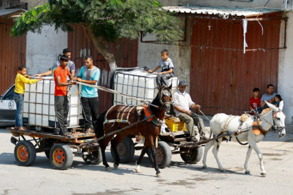 Palestinians gather to fill containers with water in the southern Gaza Strip