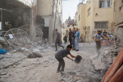 Palestinians remove rubble from a mosque which was hit in an Israeli air strike, in Jenin