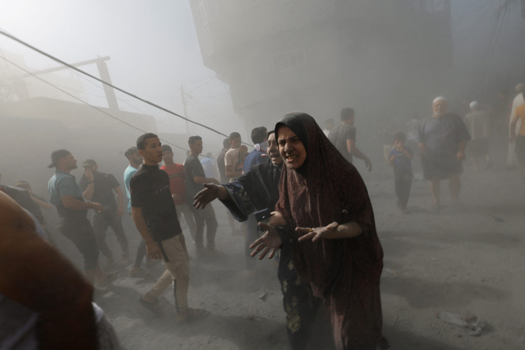Palestinians react at the site of Israeli strikes on houses, in Khan Younis