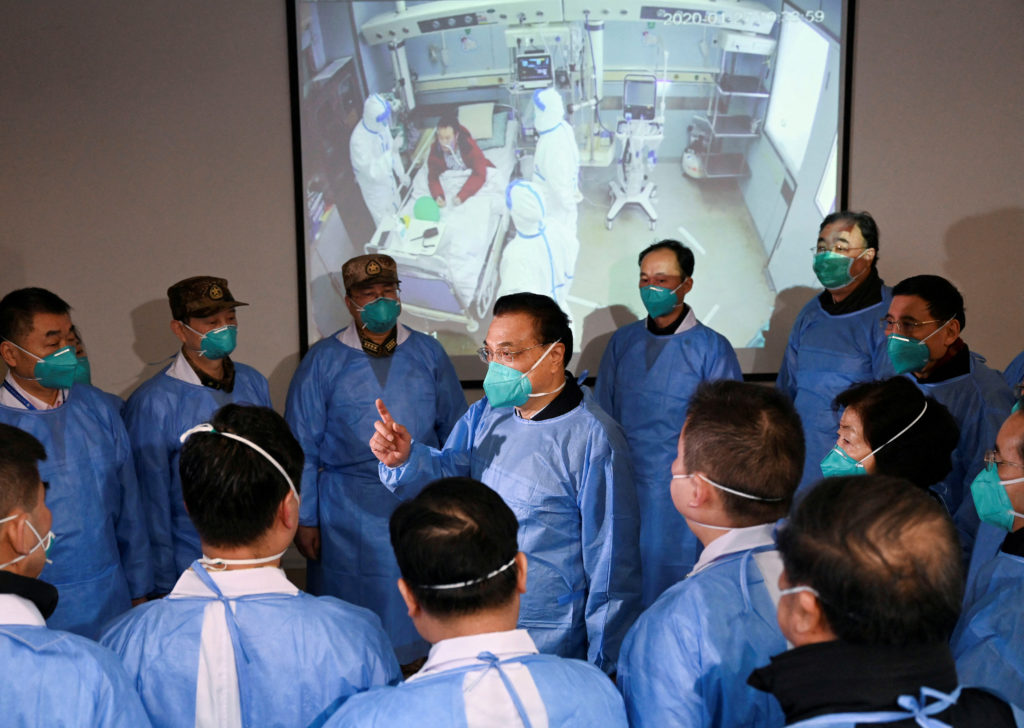 FILE PHOTO: Chinese Premier Li Keqiang wearing a mask and protective suit speaks to medical workers as he visits the Jinyi...