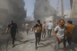 Palestinians react at the site of Israeli strikes on houses, in Khan Younis