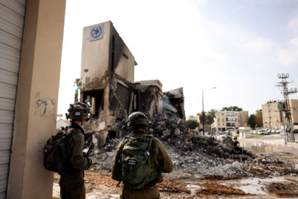Israeli soldiers look at the remains of a police station following a mass infiltration by Hamas gunmen from the Gaza Strip...