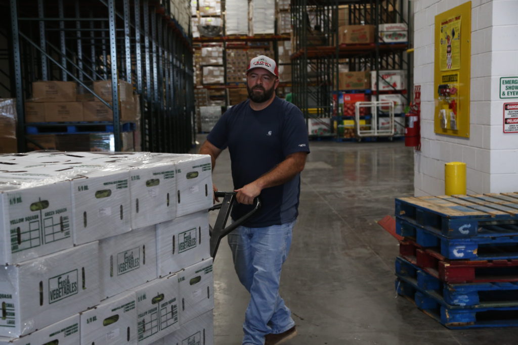 Brandon Crow delivers boxes of okra, squash, cucumbers and cantaloupe that will used to feed children in Oklahoma schools as part of a local food for local schools program. Photo by Adam Kemp, PBS NewsHour