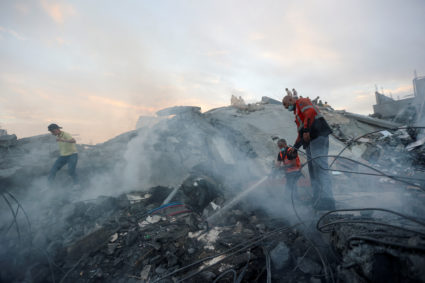 Palestinians search for casualties at the site of Israeli strikes on a residential building