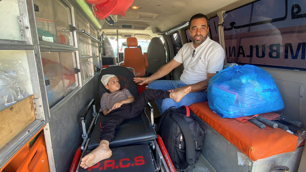 Medical workers wait to take injured Palestinians who will receive treatment in Egyptian hospitals, at the Rafah border cr...