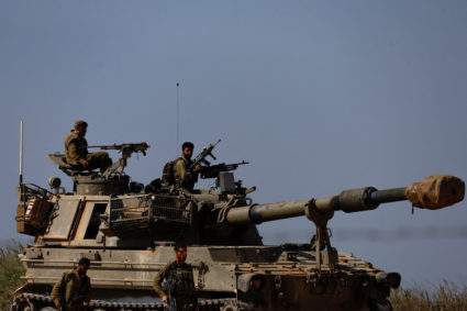Israeli soldiers ride atop an artillery unit near the Israeli side of the border between Israel and the Gaza Strip, November 3, 2023. Photo by Amir Cohen/REUTERS