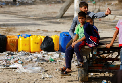 Palestinians collect water, amid a lack of clean and drinking water, as the conflict between Israel and Hamas continues, i...