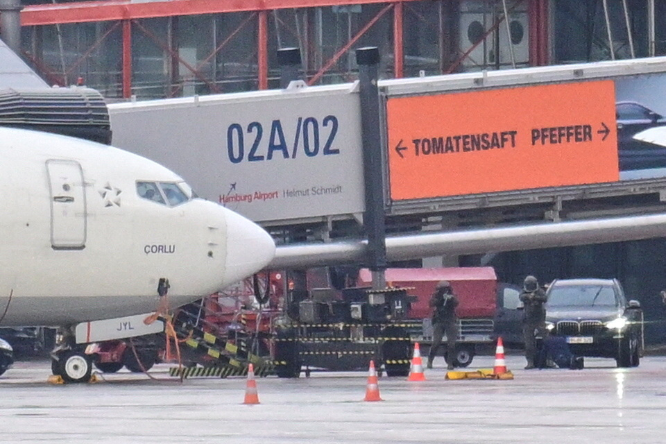 Police secure the area after a man drove through a barrier onto the grounds of the city's airport with a child in his car ...