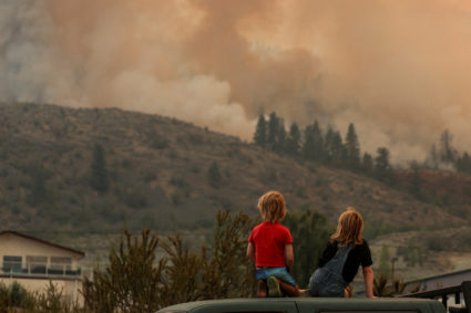 Locals gather to watch firefighting efforts amid heavy smoke from the Eagle Bluff wildfire, after it crossed the Canada-U.S. border from the state of Washington and prompted evacuation orders, in Osoyoos, British Columbia, Canada July 30, 2023. Photo by Jesse Winter/REUTERS