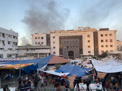 FILE PHOTO: Smoke rises as displaced Palestinians take shelter at Al Shifa hospital, amid the ongoing conflict between Ham...