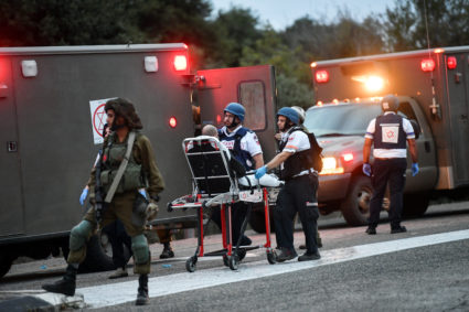 Israeli medics treat an injured man following anti-tank missiles that were fired from Lebanon towards Israel near the Isra...